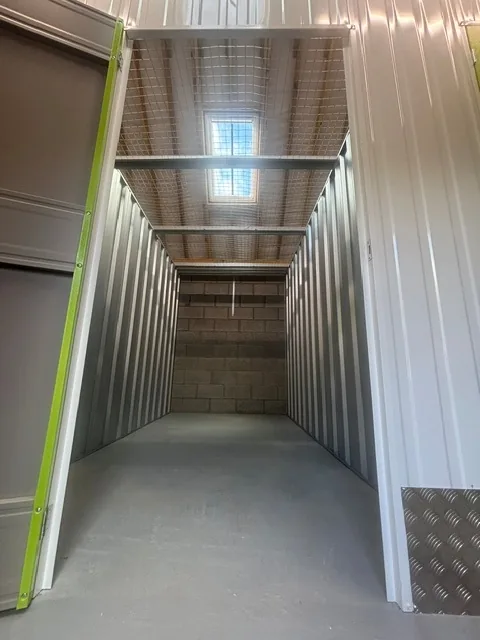 Looking into an empty storage unit: steel-lined walls, a blockwork end wall, a smooth insulated floor and rooflights above letting in daylight.